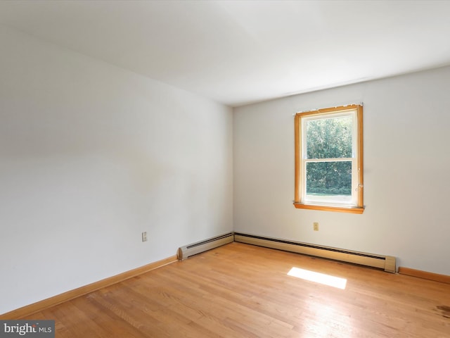 empty room with light wood-type flooring and a baseboard radiator