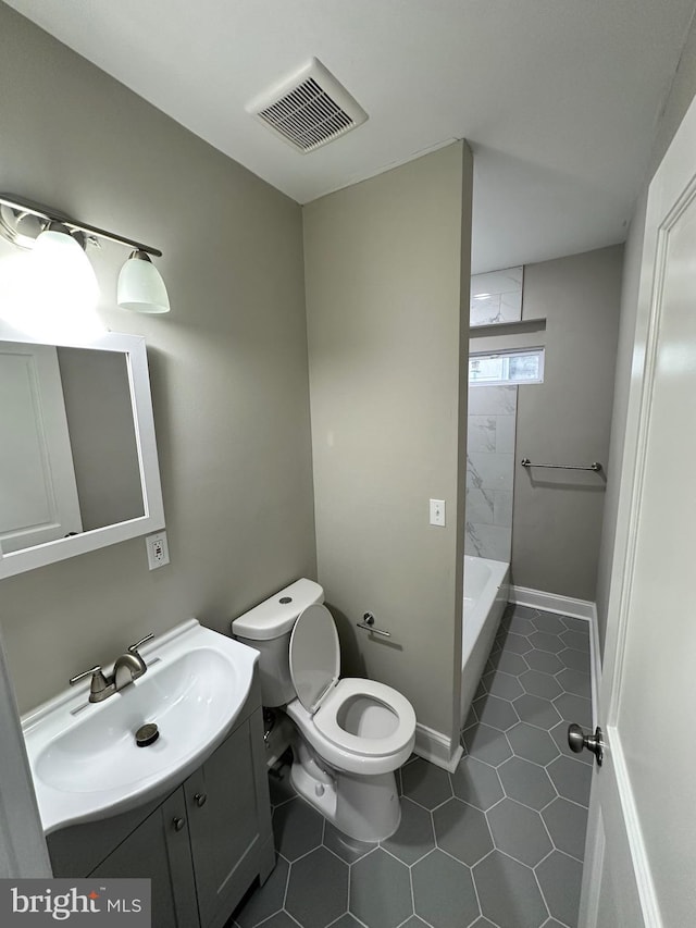 bathroom with tile patterned flooring, vanity, a tile shower, and toilet