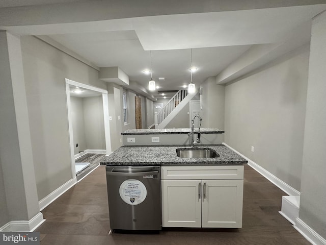 kitchen featuring pendant lighting, sink, white cabinets, stainless steel dishwasher, and dark stone counters