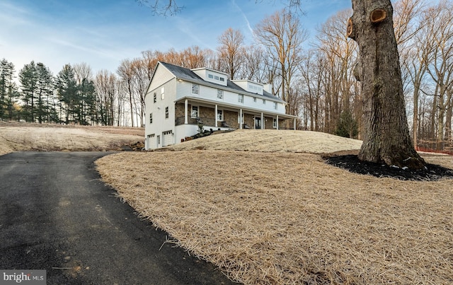 view of home's exterior with covered porch and a garage