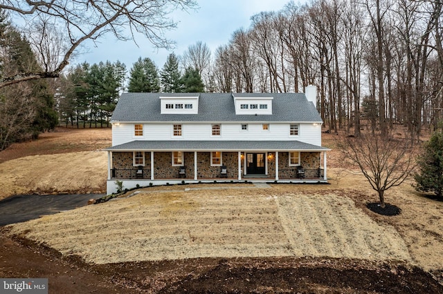 view of front of property with covered porch and a front yard