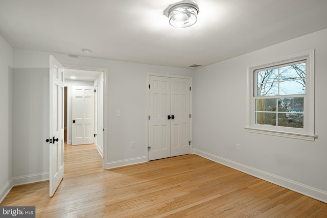 unfurnished bedroom featuring light hardwood / wood-style floors and a closet