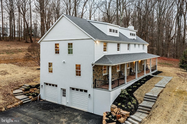 exterior space with a porch and a garage