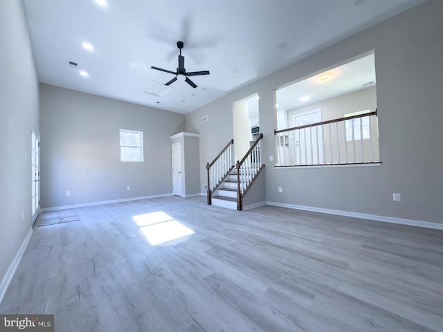 unfurnished living room featuring ceiling fan and light wood-type flooring