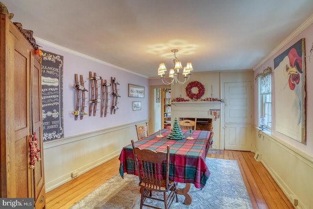 dining space featuring a chandelier, light wood-type flooring, and ornamental molding