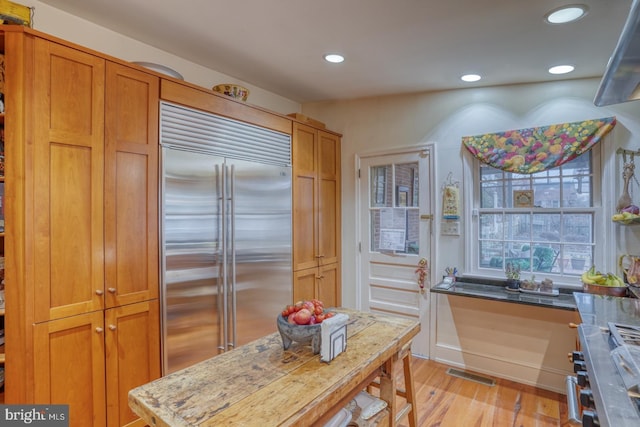 kitchen with high quality appliances and light hardwood / wood-style floors