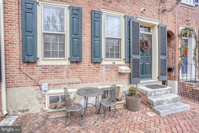 view of exterior entry featuring a patio area