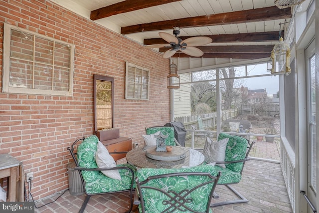 unfurnished sunroom with beamed ceiling, ceiling fan, and wood ceiling