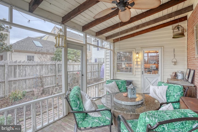 sunroom / solarium with lofted ceiling with beams, ceiling fan, and wooden ceiling