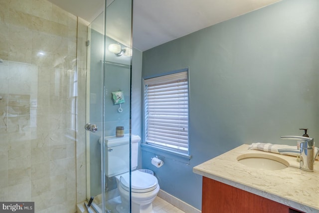 bathroom with tile patterned flooring, vanity, a shower with shower door, and toilet