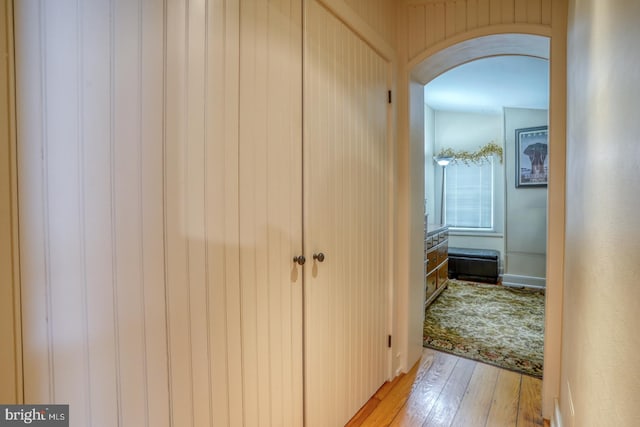 hallway featuring wood walls and light hardwood / wood-style floors