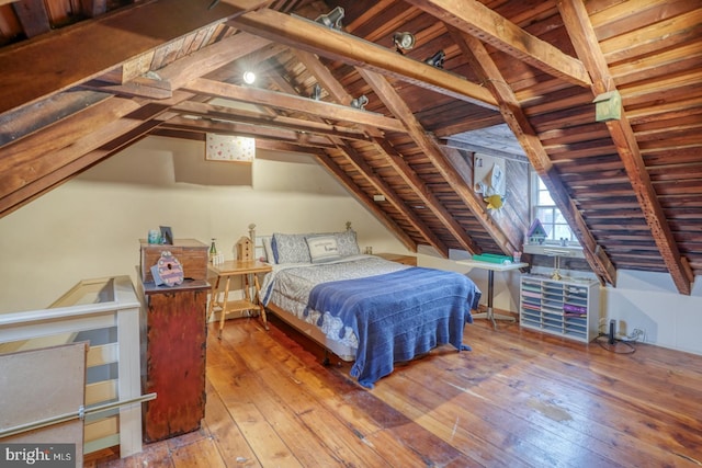 bedroom featuring hardwood / wood-style flooring, vaulted ceiling with beams, and wooden ceiling