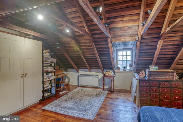 unfurnished bedroom featuring dark hardwood / wood-style flooring, heating unit, vaulted ceiling, and wood ceiling