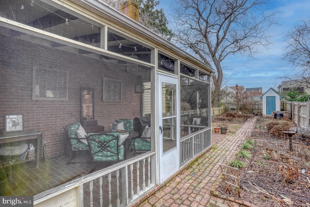 view of home's exterior with a shed and a sunroom