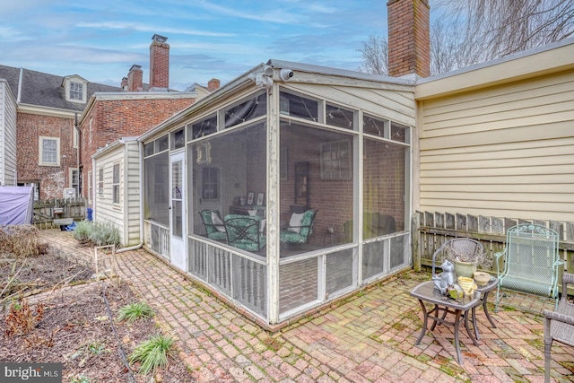 back of property with a sunroom and a patio