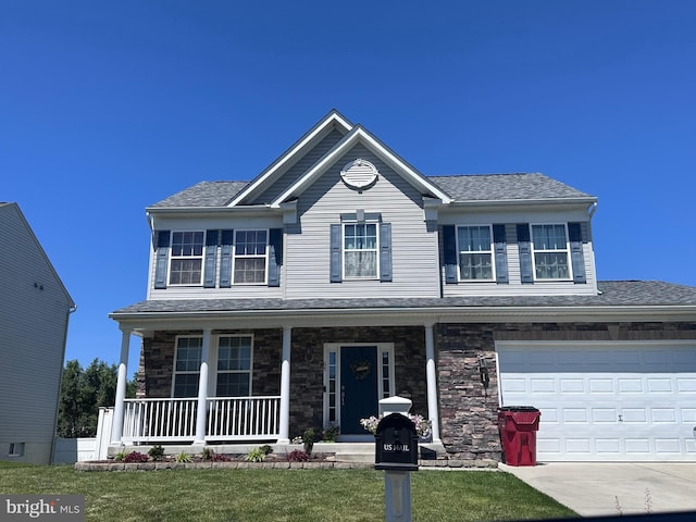 view of front of home featuring a garage, covered porch, and a front lawn