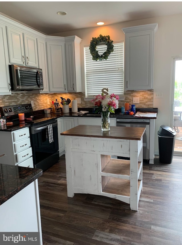 kitchen featuring black electric range, white cabinetry, stainless steel dishwasher, and dark hardwood / wood-style floors