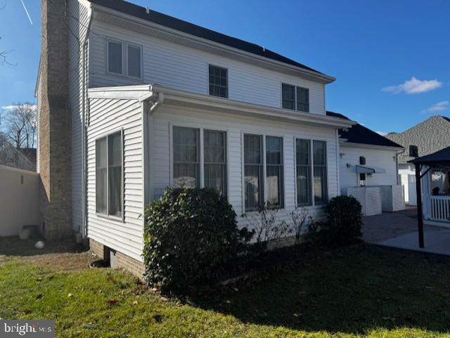 view of side of home with a yard