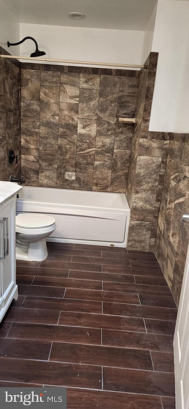 full bathroom featuring vanity, toilet, and tiled shower / bath combo