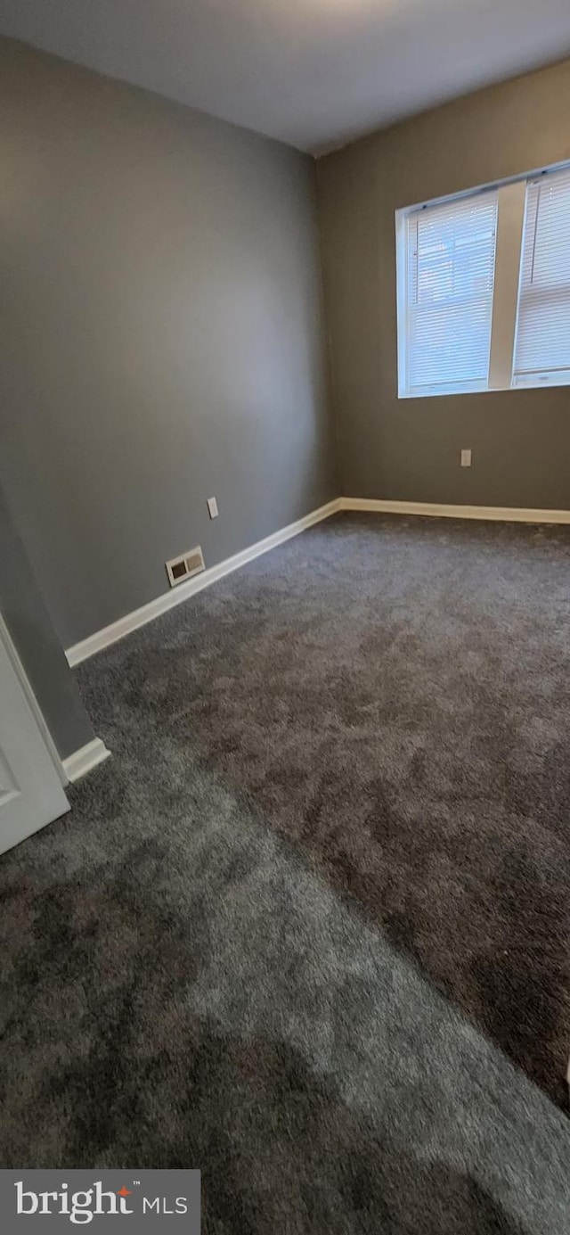 empty room with dark carpet