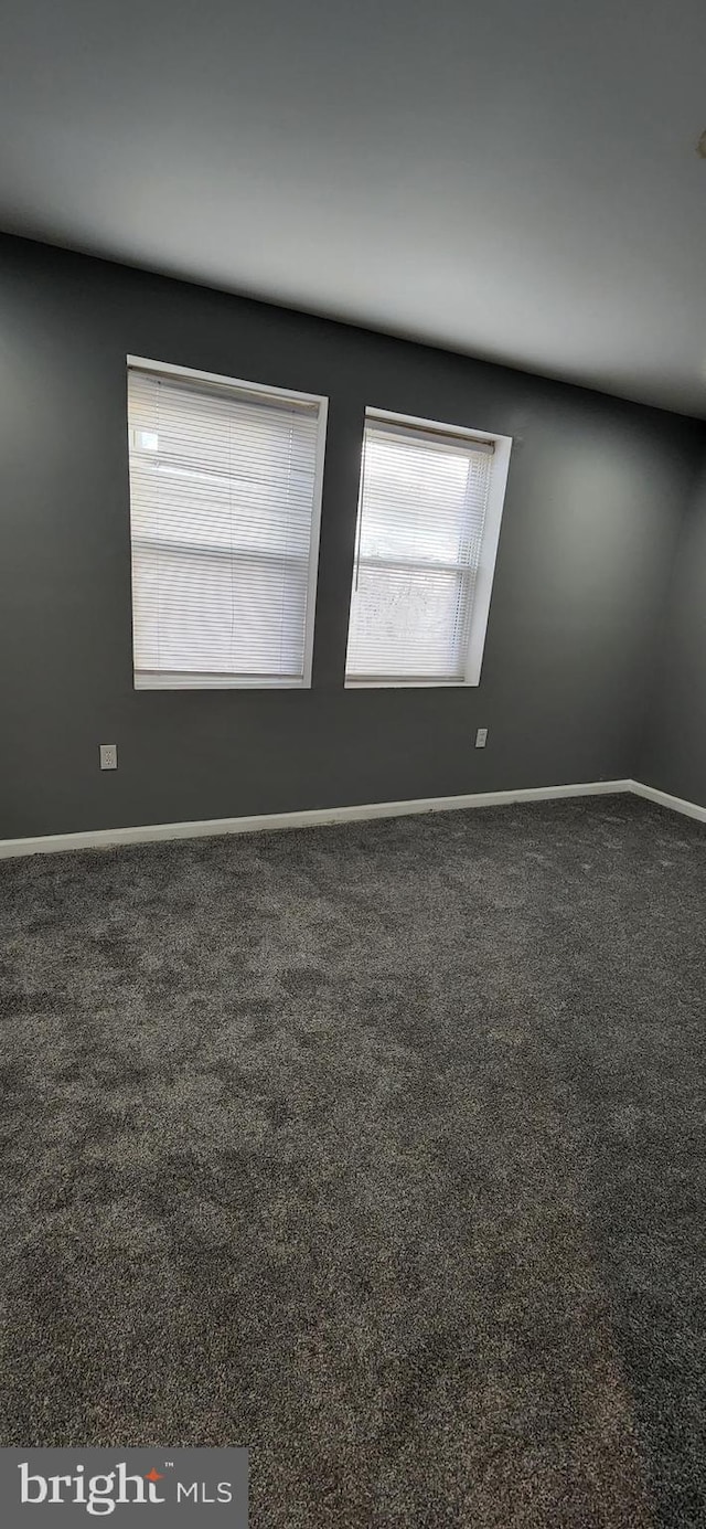 empty room featuring dark carpet