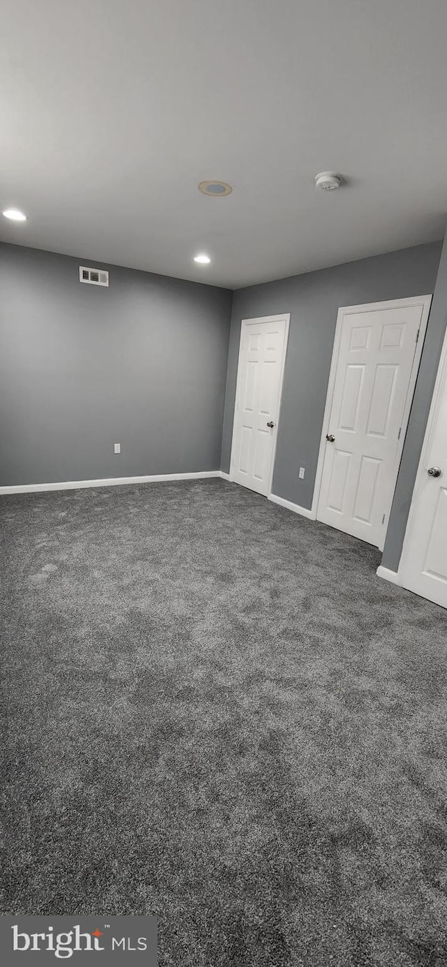 unfurnished bedroom with dark carpet