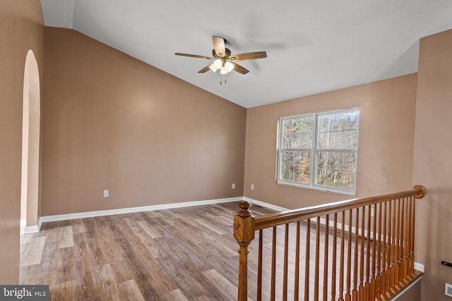 stairs featuring hardwood / wood-style flooring, ceiling fan, and lofted ceiling