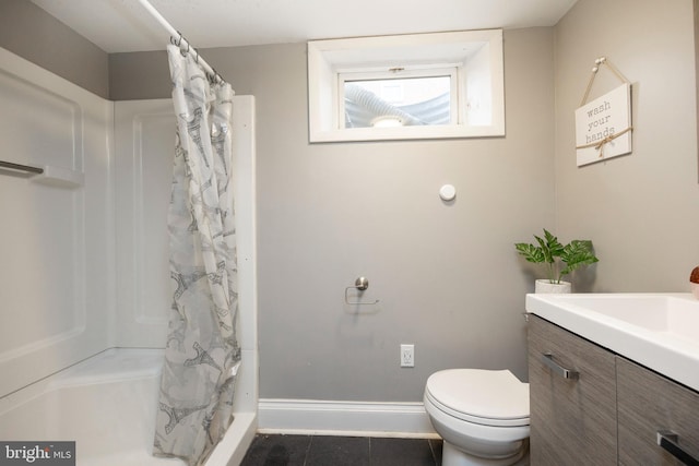 bathroom featuring tile patterned floors, vanity, toilet, and walk in shower