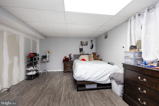 bedroom featuring a paneled ceiling and hardwood / wood-style flooring