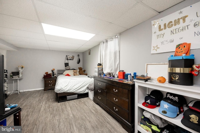 bedroom with light hardwood / wood-style flooring and a drop ceiling