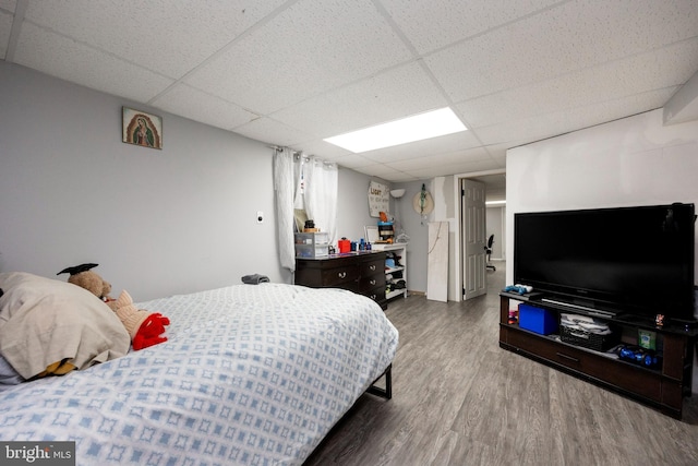 bedroom with hardwood / wood-style floors and a drop ceiling