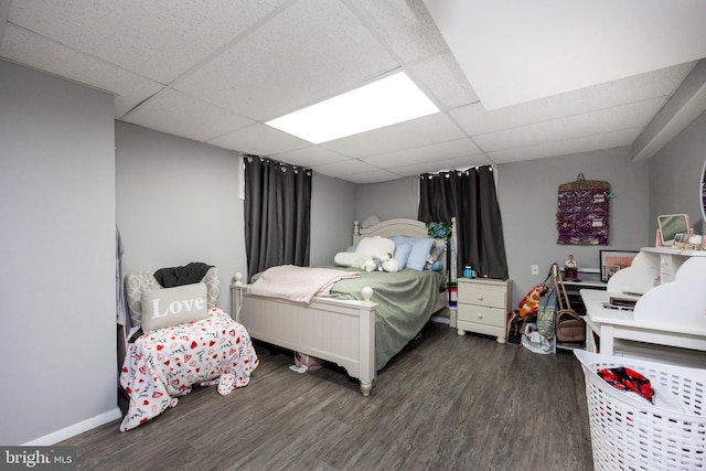 bedroom featuring a drop ceiling and dark hardwood / wood-style floors