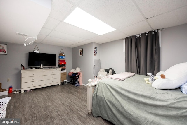 bedroom with hardwood / wood-style floors and a drop ceiling