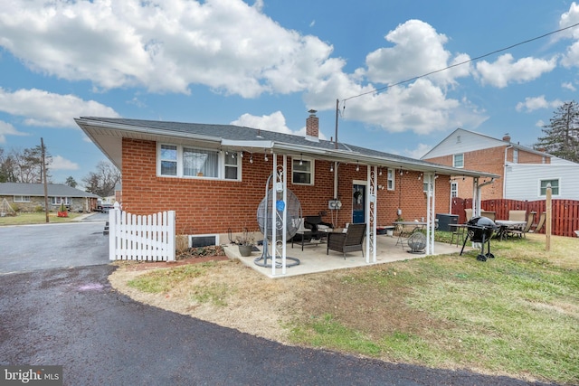 back of property with a patio area and a lawn