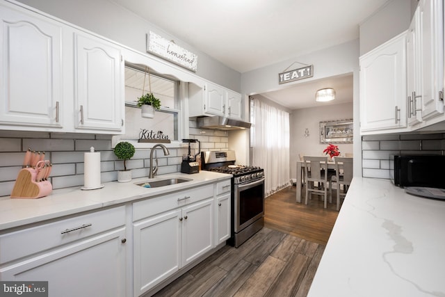 kitchen featuring dark hardwood / wood-style flooring, tasteful backsplash, stainless steel range with gas cooktop, sink, and white cabinetry