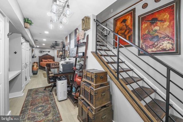 stairs with hardwood / wood-style flooring and a notable chandelier