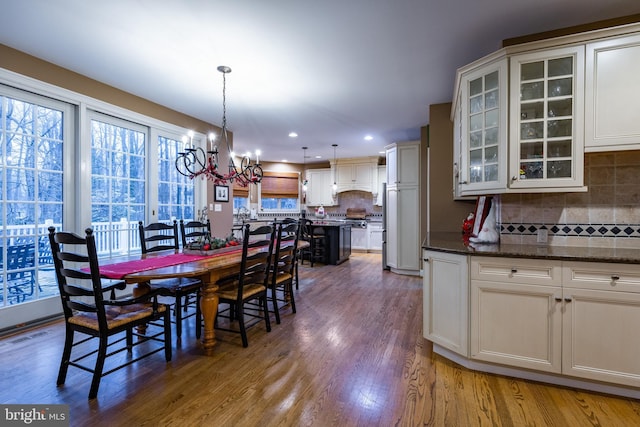 dining room with dark hardwood / wood-style flooring and an inviting chandelier