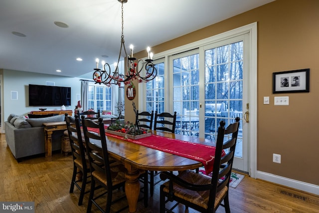 dining area with hardwood / wood-style flooring and a notable chandelier