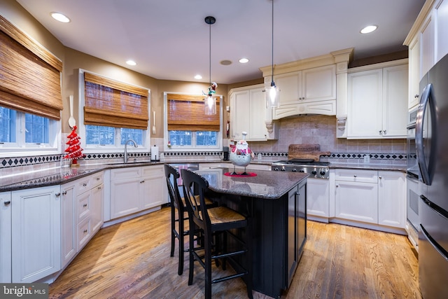 kitchen featuring white cabinets, a center island, and sink