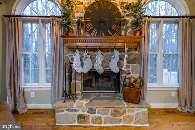 interior details featuring a fireplace and wood-type flooring