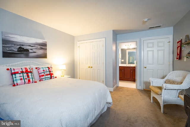 bedroom featuring connected bathroom and light carpet