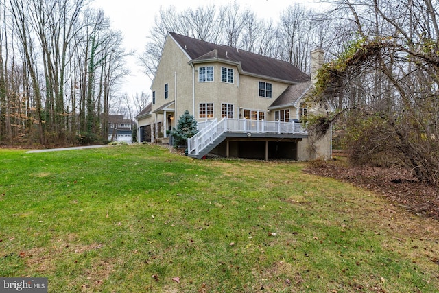 rear view of house with a yard and a wooden deck