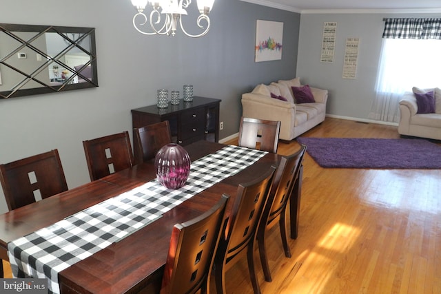 dining area featuring ornamental molding, a chandelier, and light wood-type flooring