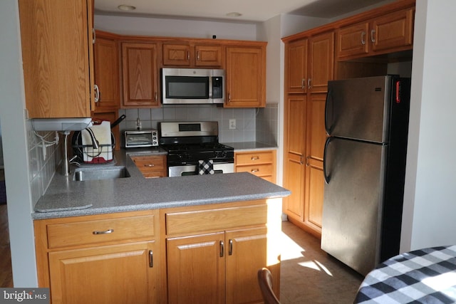 kitchen with appliances with stainless steel finishes, backsplash, and sink