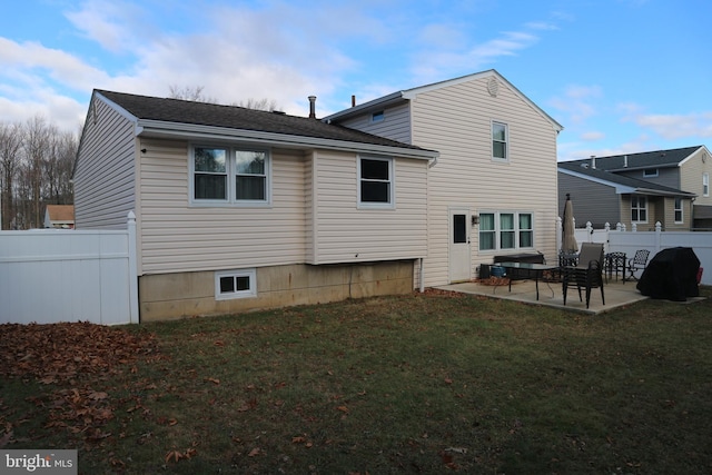 rear view of house with a yard and a patio