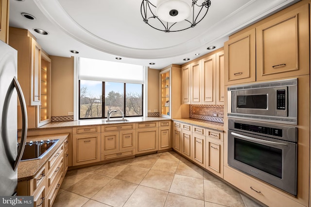 kitchen featuring tasteful backsplash, appliances with stainless steel finishes, light brown cabinetry, and sink