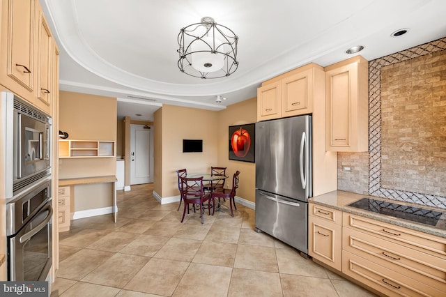 kitchen featuring light tile patterned floors, appliances with stainless steel finishes, tasteful backsplash, a tray ceiling, and light brown cabinetry