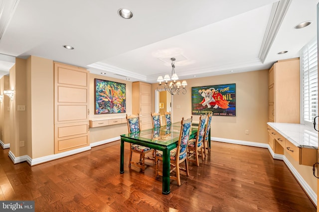 dining space featuring an inviting chandelier, a tray ceiling, and dark hardwood / wood-style flooring