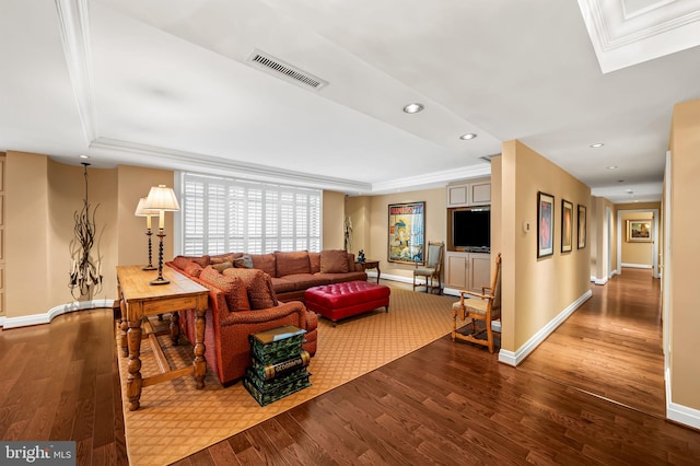 living room featuring crown molding, a tray ceiling, and hardwood / wood-style floors