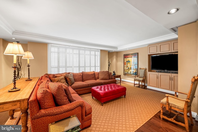 living room with ornamental molding, a raised ceiling, and light hardwood / wood-style flooring